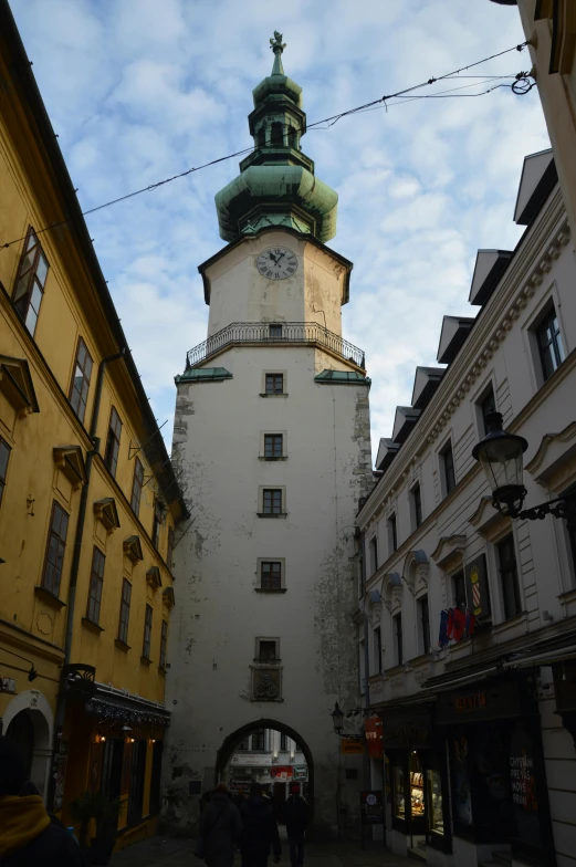 two buildings with people walking by on a cobblestone street