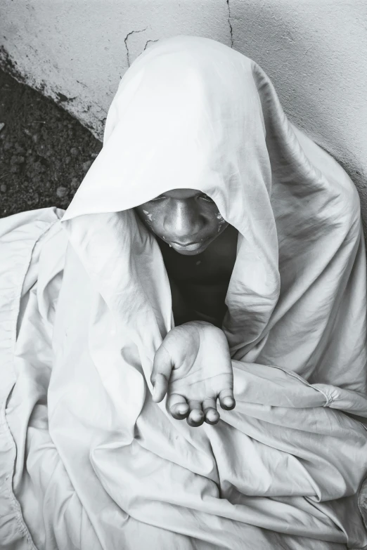 an image of a black and white po of a person wrapped in blankets