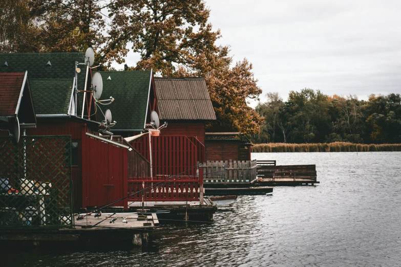 a red house in front of the water