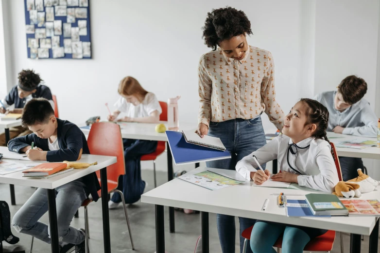 a couple of children are taking notes on desks