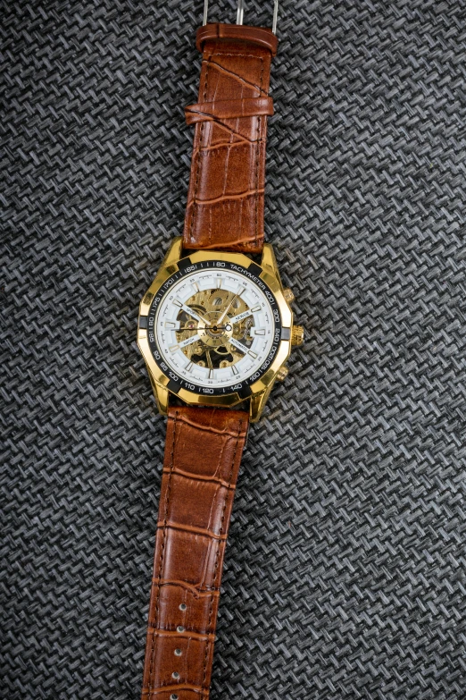 a gold watch that is sitting on a surface