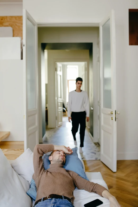 a man lying on his back while walking down the hall way