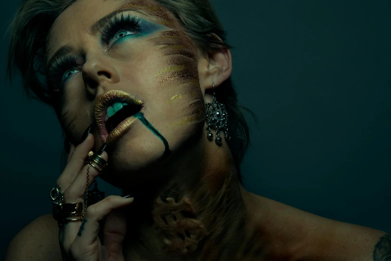 a woman in blue and gold makeup with different hands