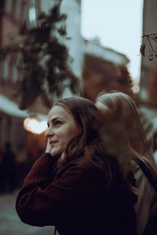 a woman in red jacket holding her hand near her head