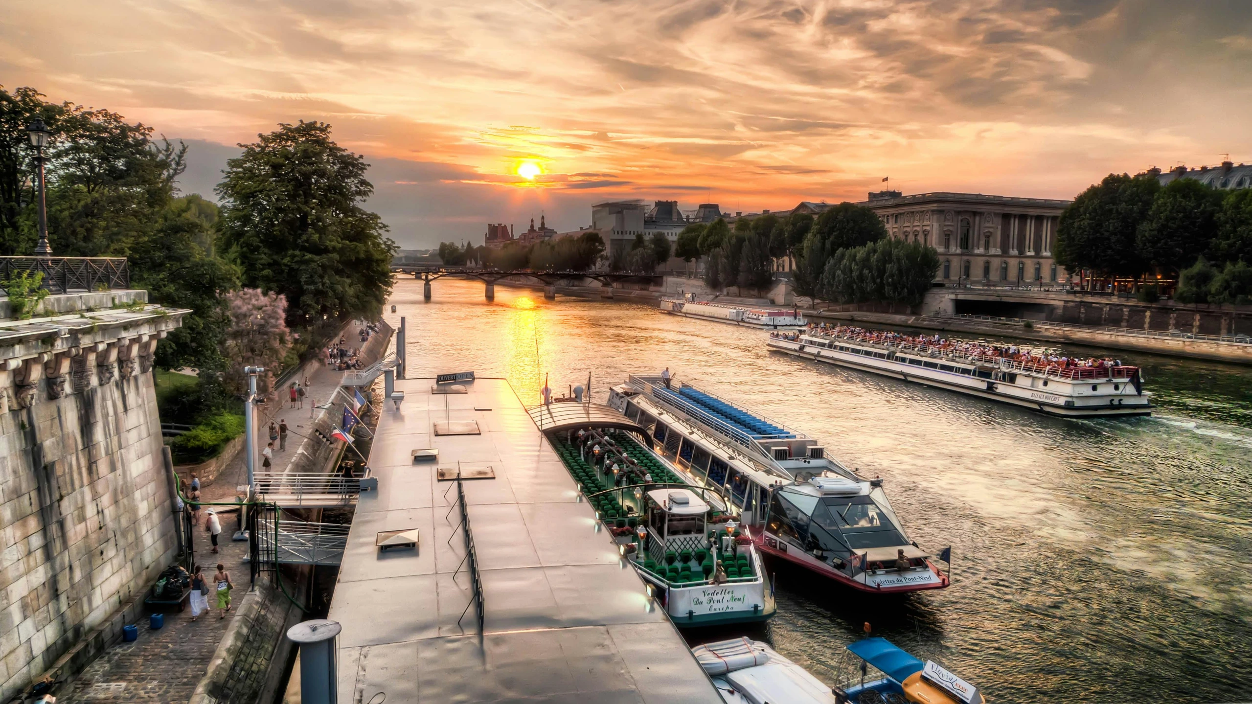 several boats floating on a river near buildings