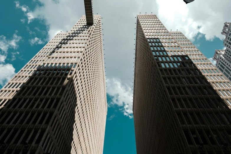 looking up at two high rise buildings against blue sky