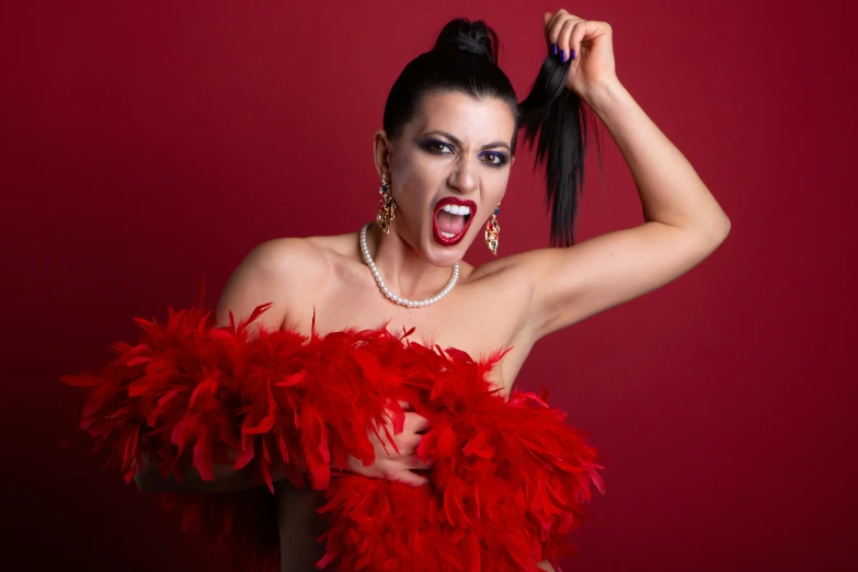 a beautiful woman with feathery red dress holding her hair