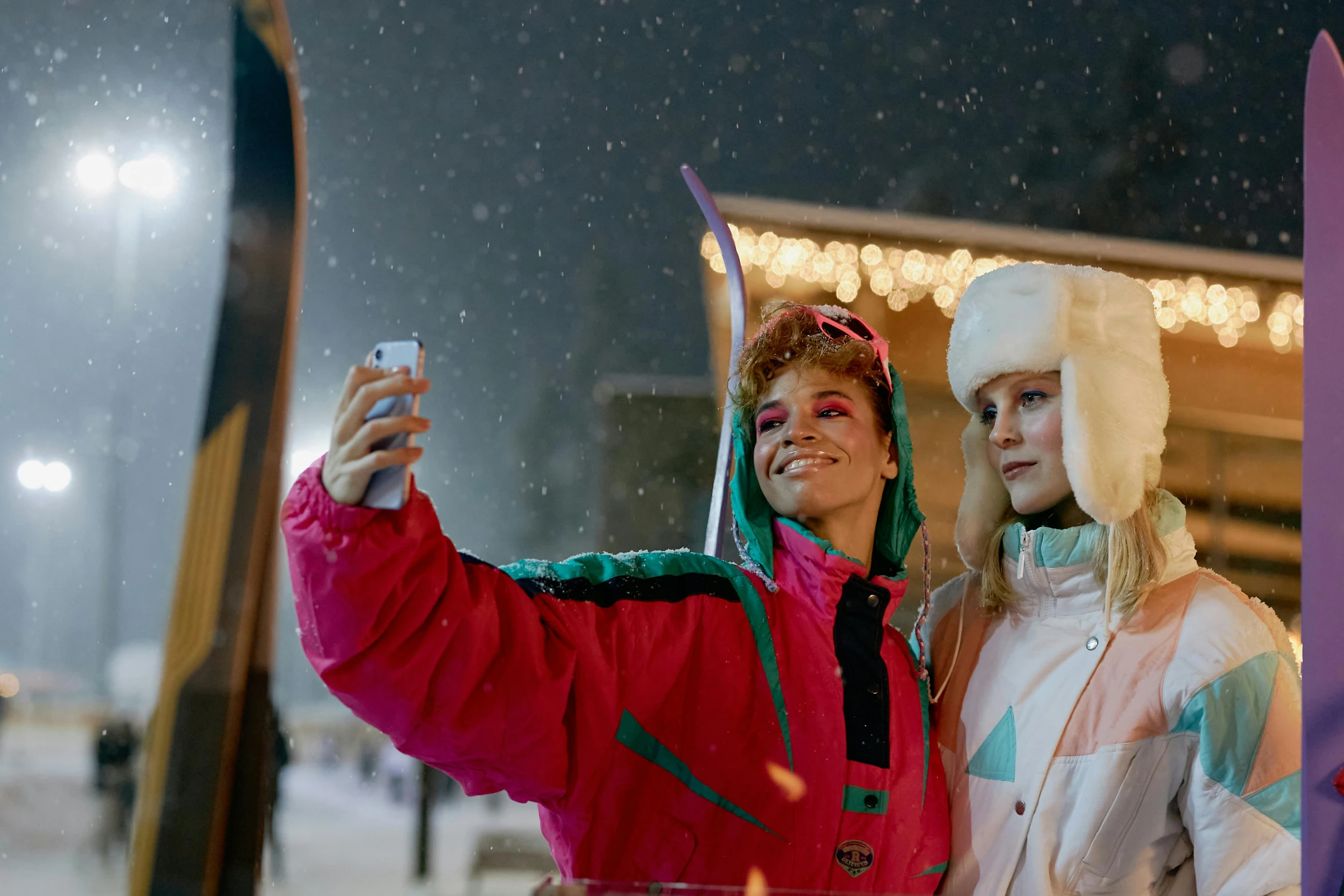 two women taking a selfie while holding their skis