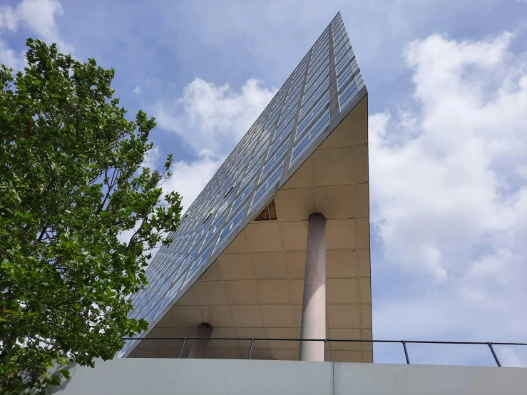 a tall building with a triangular roof and a fence above it