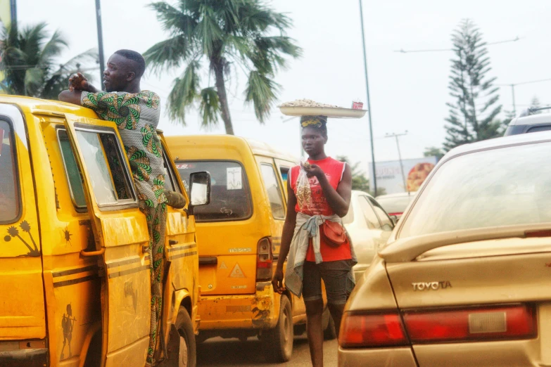 a man standing near several parked cars in traffic