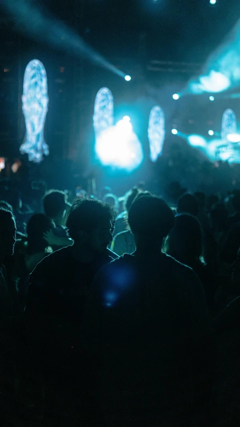 people watching a concert in a dimly lit auditorium