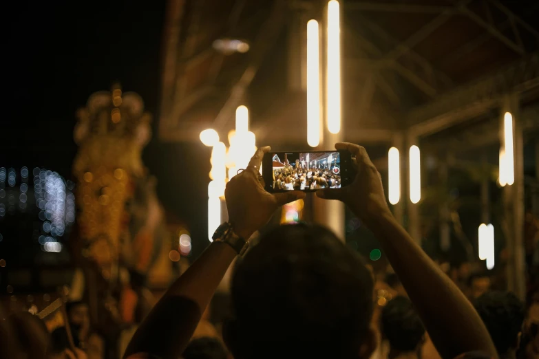 people are standing around taking pictures of themselves in front of a crowd