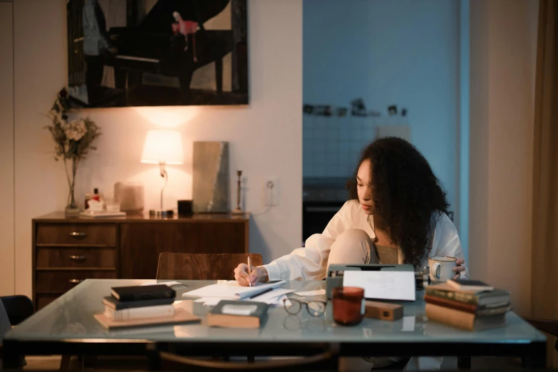 a woman sitting at a table with lots of books on it