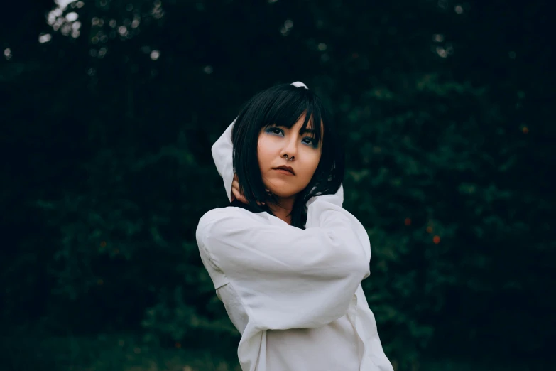 a woman wearing a hooded jacket and looking off to the side