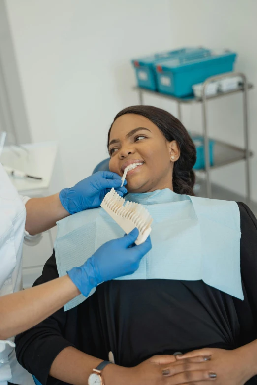 a woman smiles as she is getting her teeth brushed