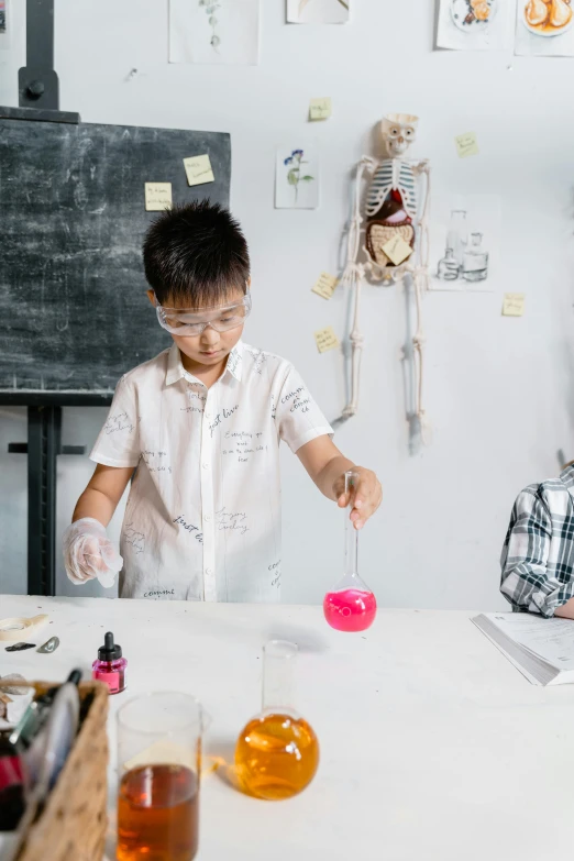 a little boy sitting at a table with a candle