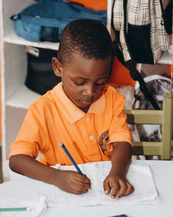 a little boy doing soing with a blue pen