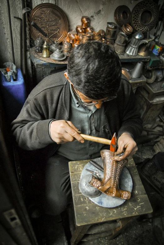 a man sits in front of a shoe sculpture