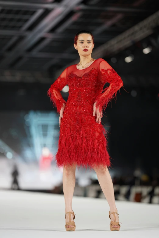 a woman in red dress on a runway