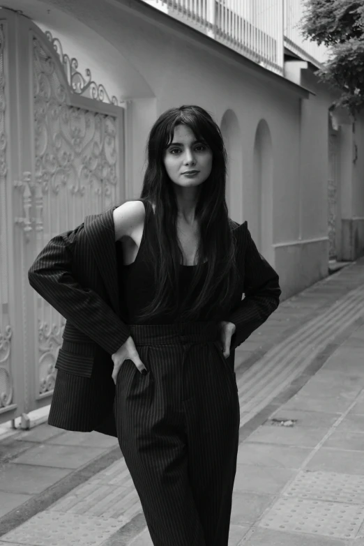 a woman stands on the street posing for the camera