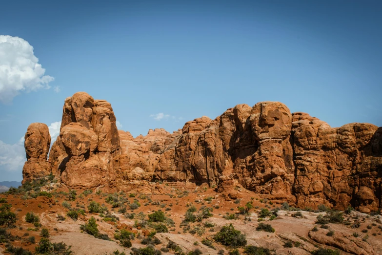 a small herd of sheep grazing next to some rocky formations