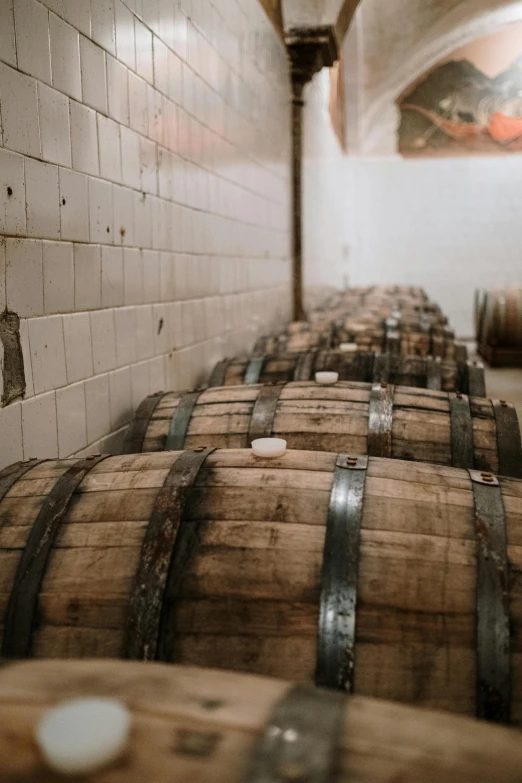 several barrels lined up in a line inside of a warehouse