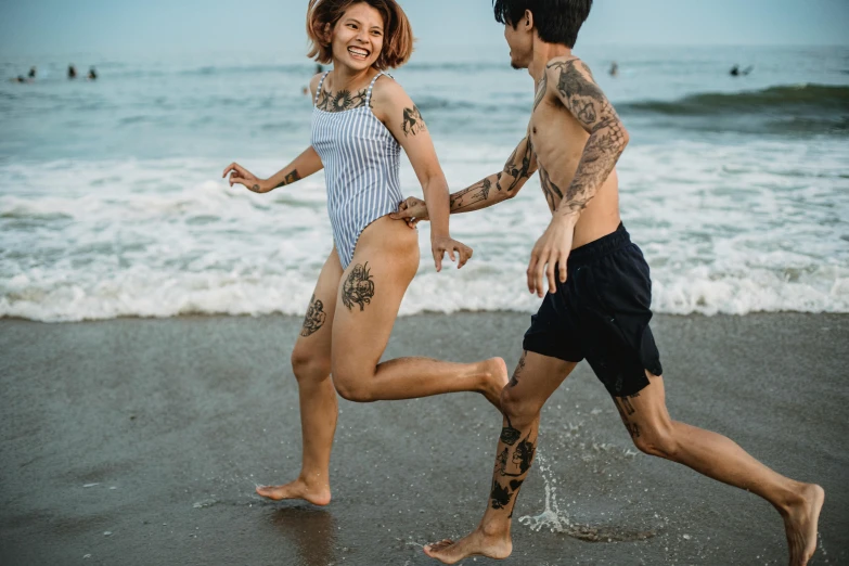 two people running on the beach near the ocean