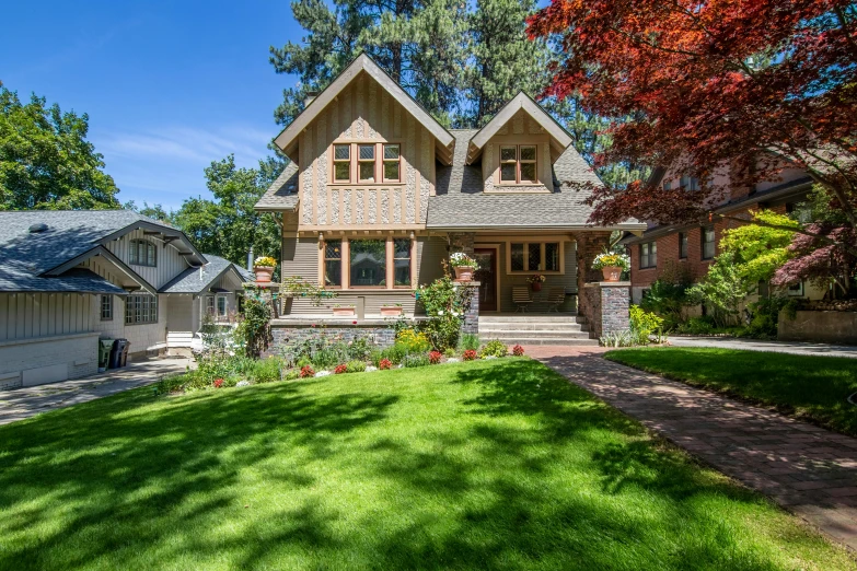 a home with a grassy lawn, driveway, and large trees