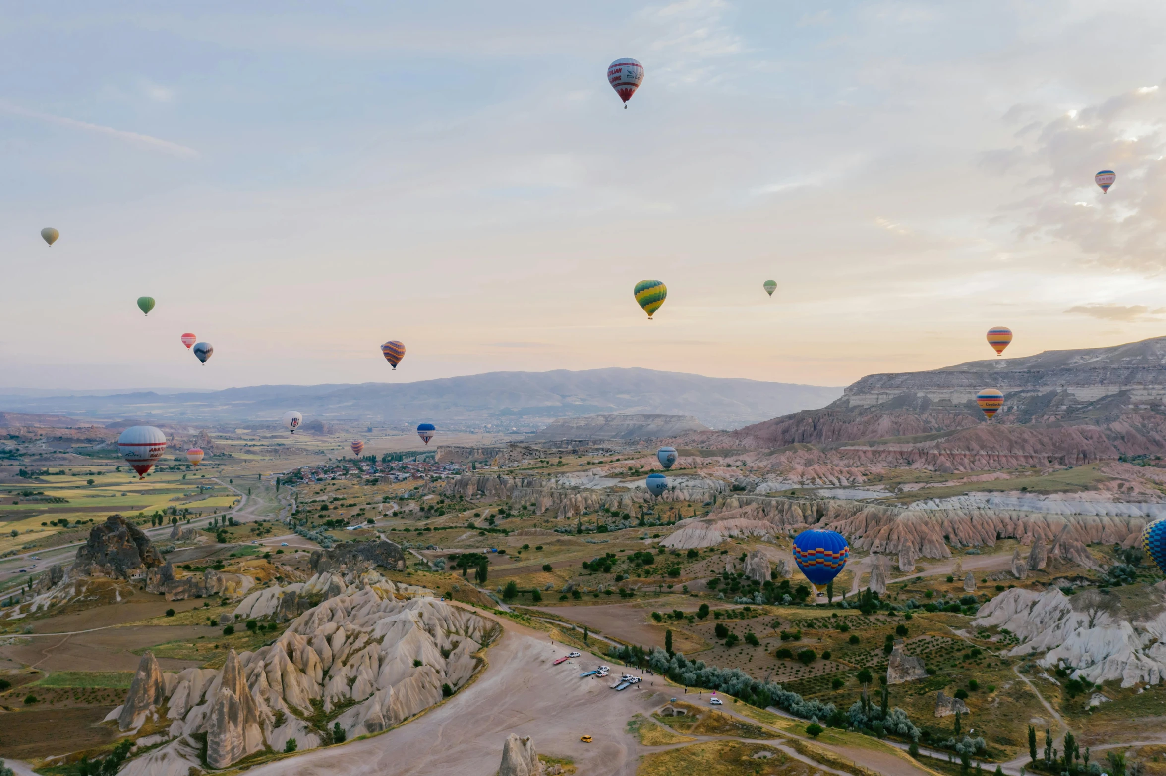 several  air balloons floating over land in the air