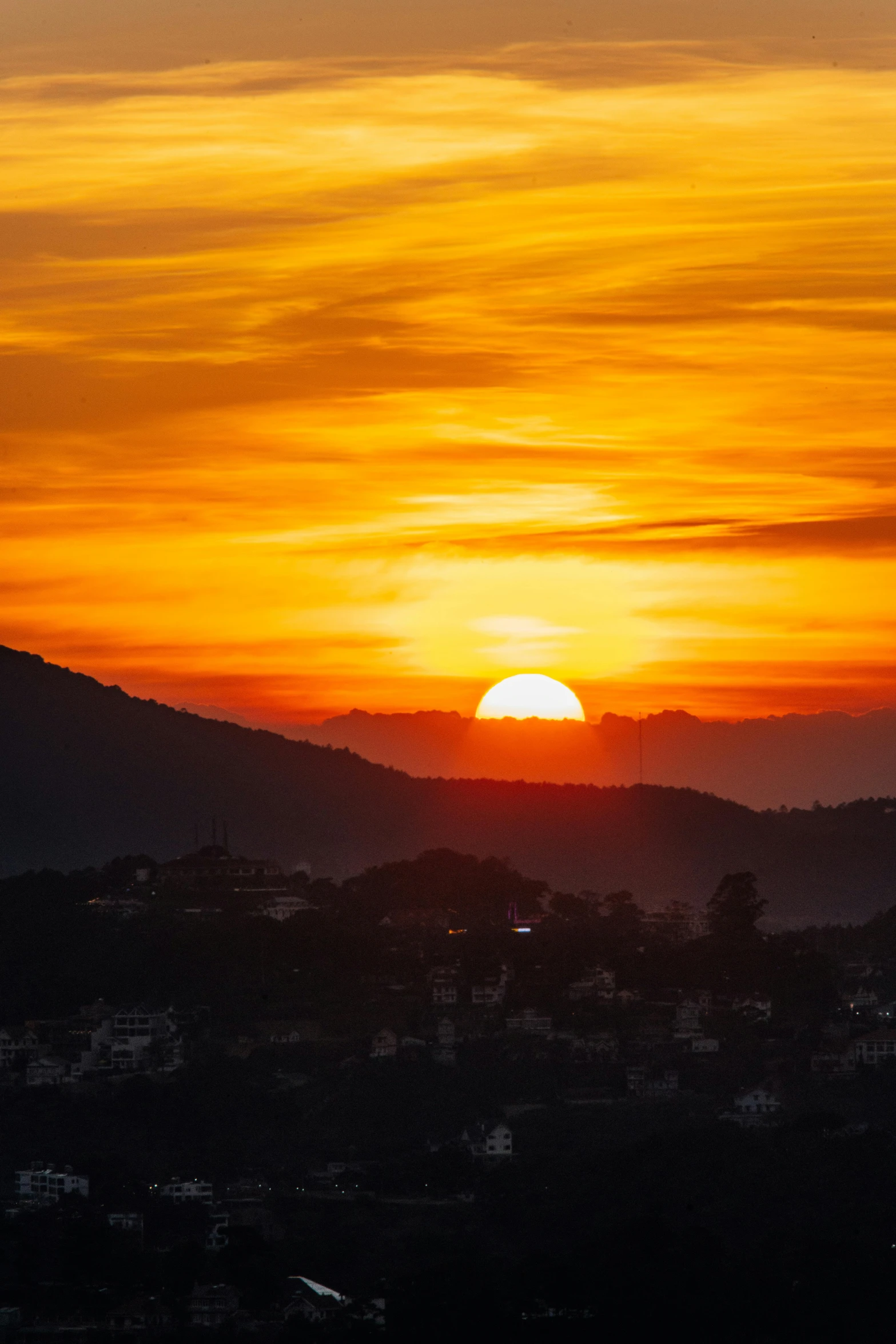 the sun is rising in the background of a mountain range