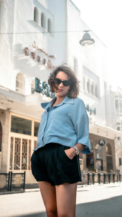 a woman posing for the camera in front of a building