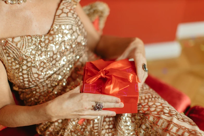 the woman is holding a red gift box with a bow