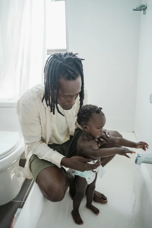 a woman with dreadlocks petting a small baby