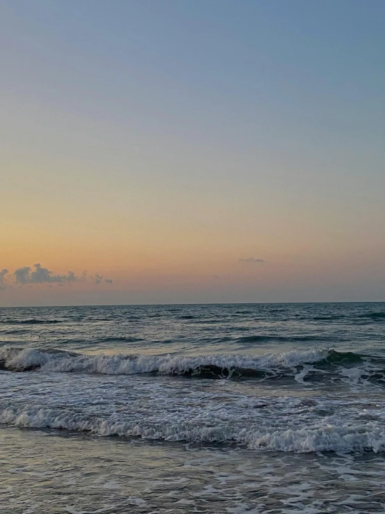 a surfboard sitting on the end of a sandy beach