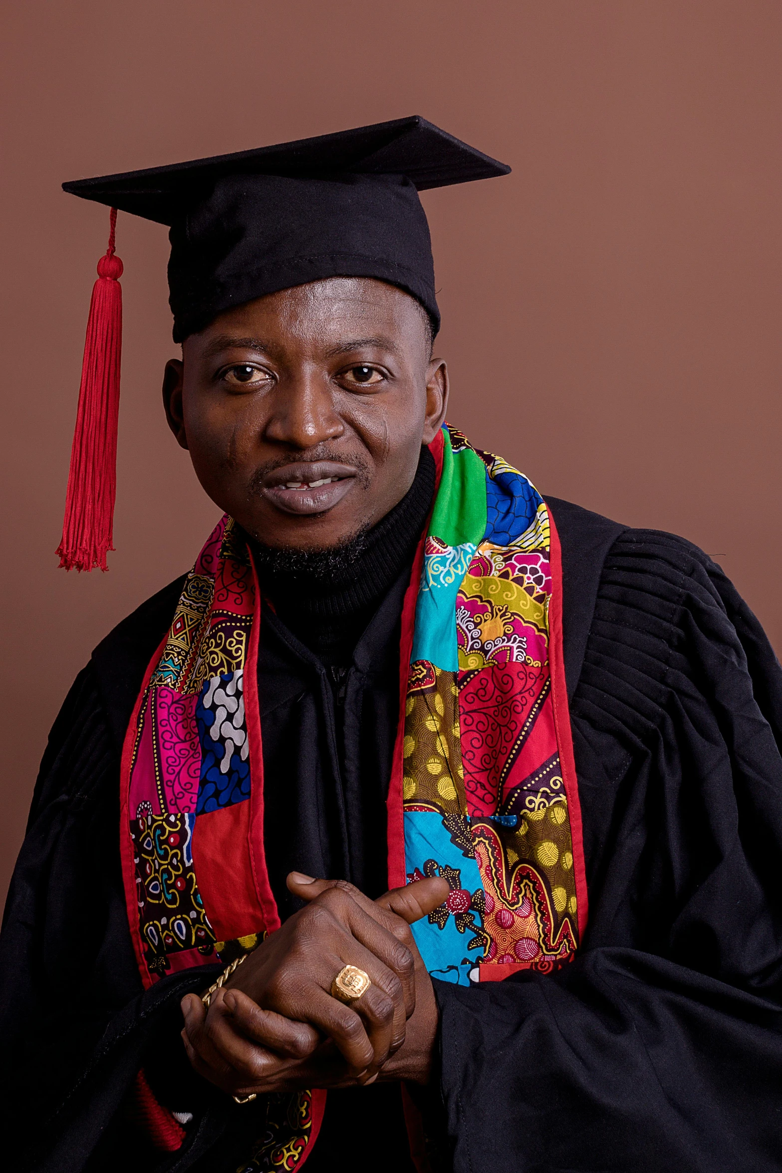 a man with a red scarf and graduation cap