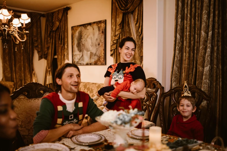 a couple and their children are sitting at the dinner table