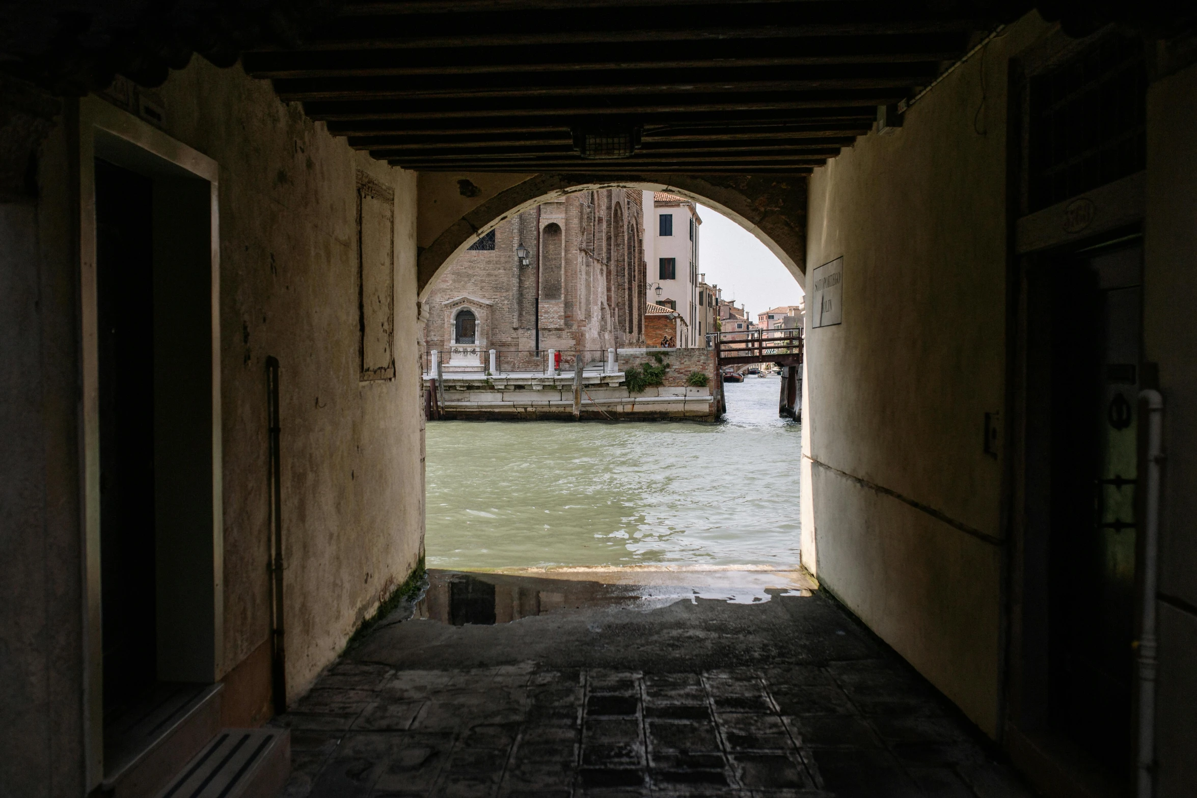 an arched hallway leading into a very narrow waterway