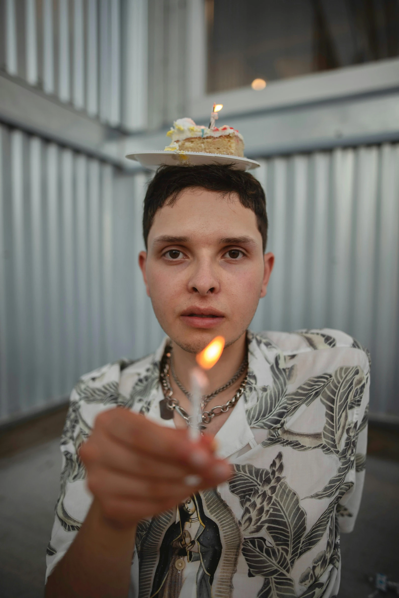 a boy in a white shirt holding a lit candle