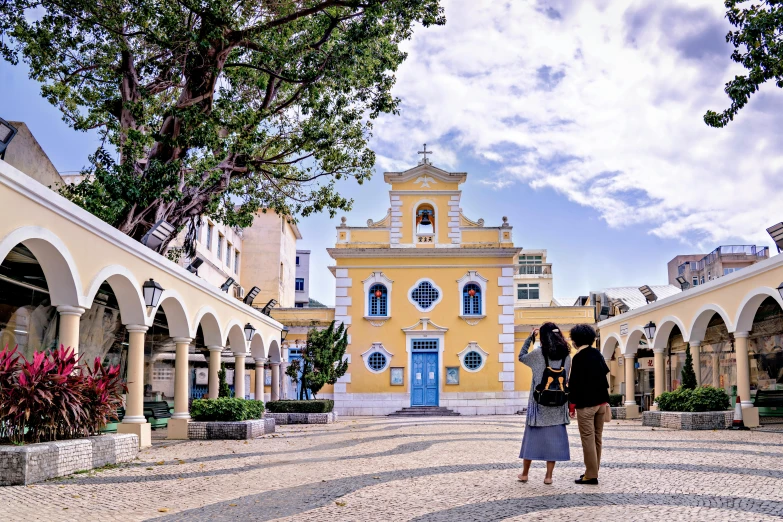 two people standing in front of a very old church