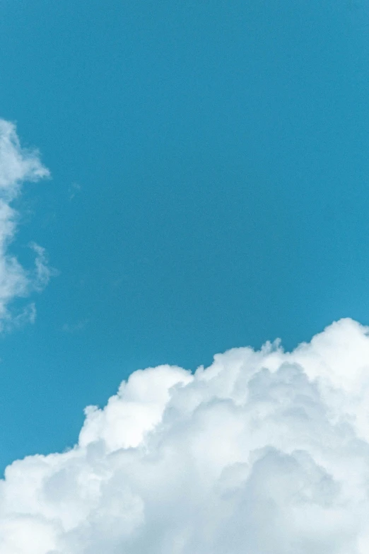 a jet is flying above clouds with blue sky