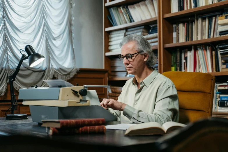 an older man working at his desk in the liry