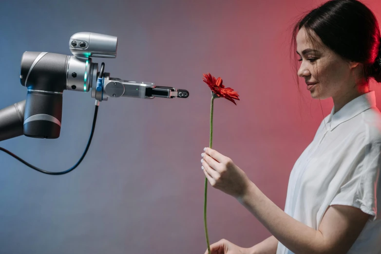 a girl standing holding a flower in her hands