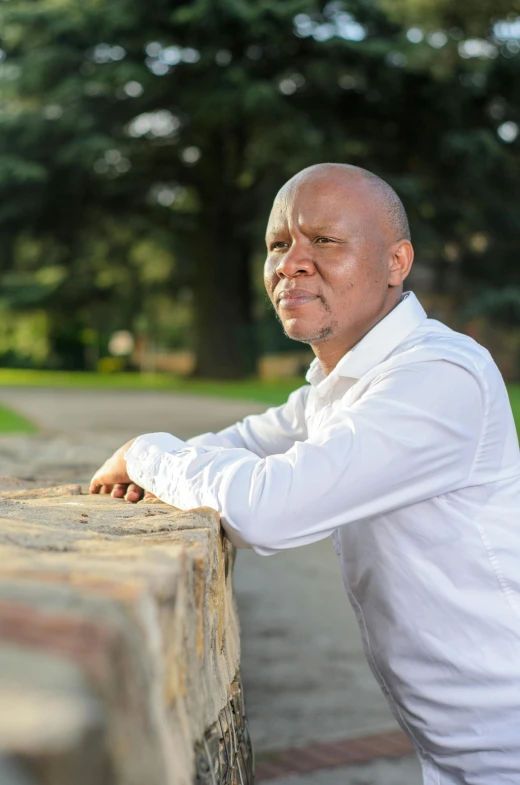 an older man leans on the end of a table