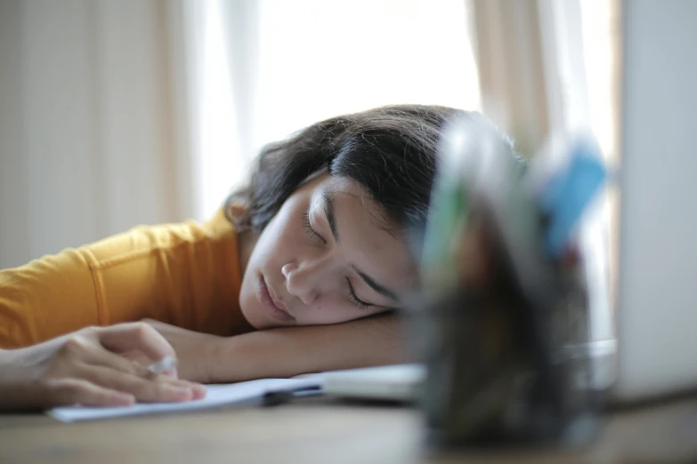 a young woman is laying down and writing