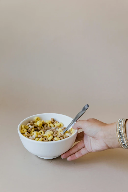 hand holding up bowl of cereal and spoon