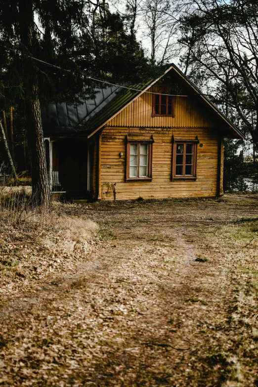 there is a small yellow house near some trees