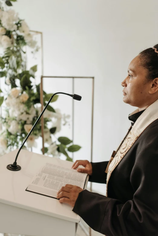 a woman reading a book at a ceremony