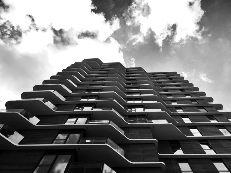 a tall building with multiple stories against a cloudy sky