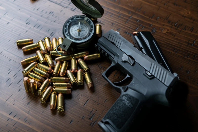 some ammo and a gun on top of a wooden table