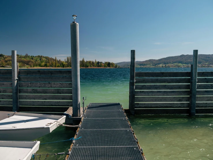 a long dock sits on the water with boats in the water